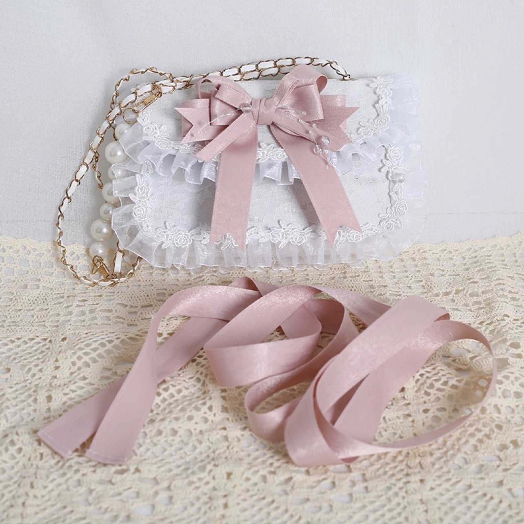 White lace purse with pastel pink bow and gold chain
