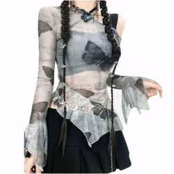 Model wearing sheer butterfly mesh top with flared ruffle sleeves and asymmetric off-shoulder cut