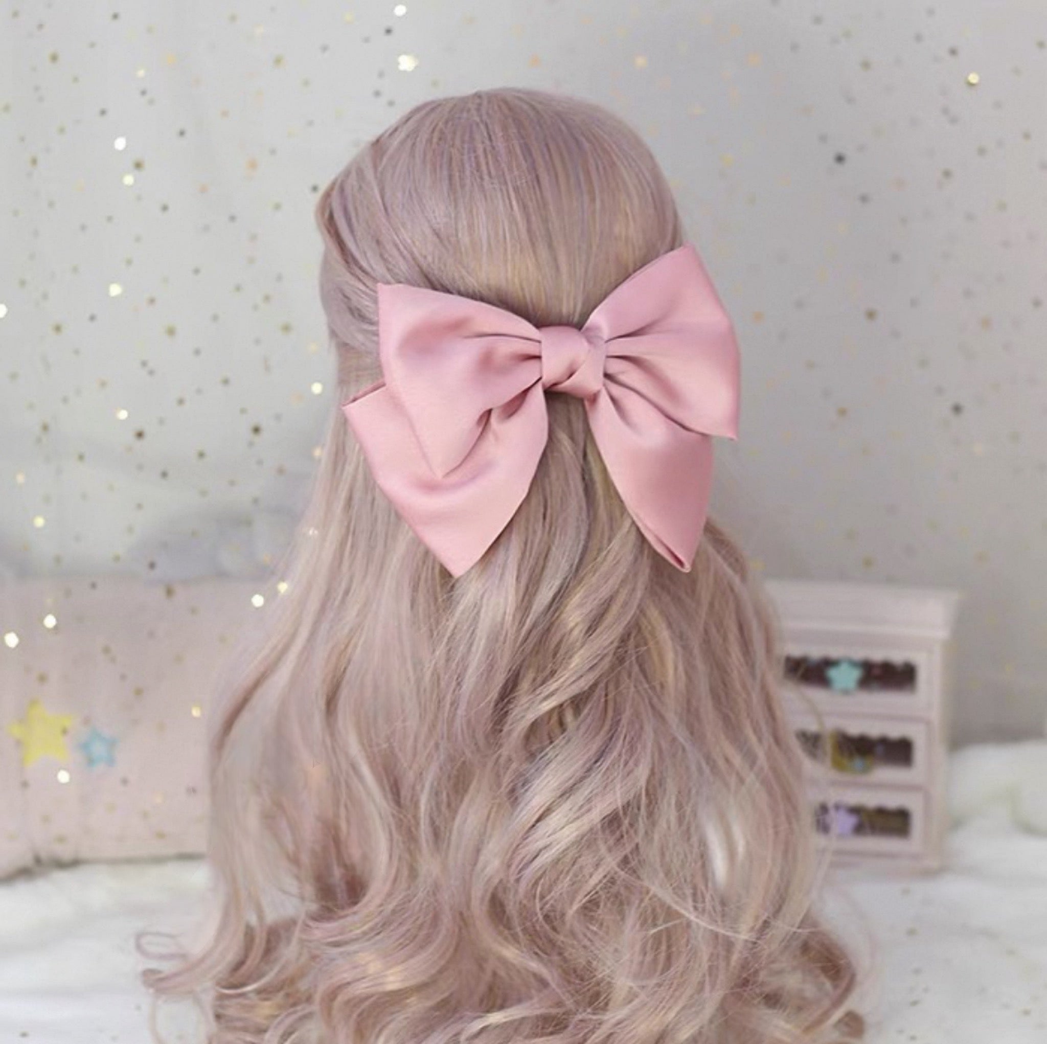 Light pink large satin bow hair accessory with soft shine and romantic curls, perfect for kawaii outfits